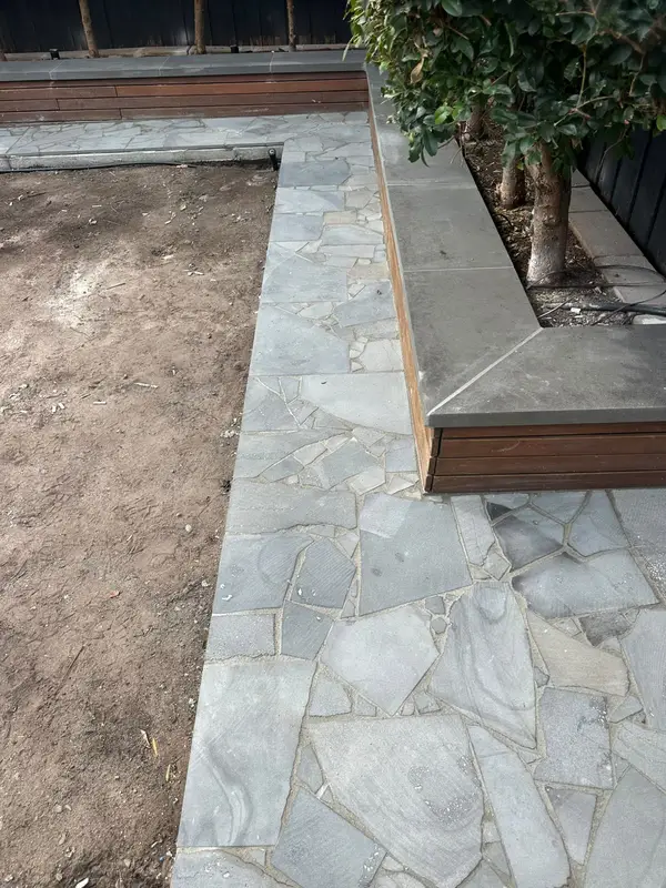 Bluestone crazy paving courtyard around a planter