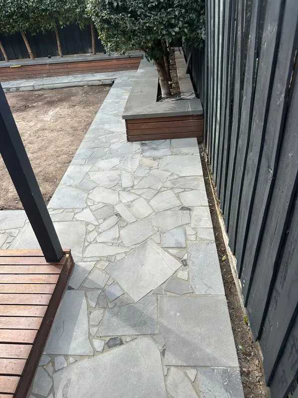 Bluestone crazy paving garden path beside a timber planter