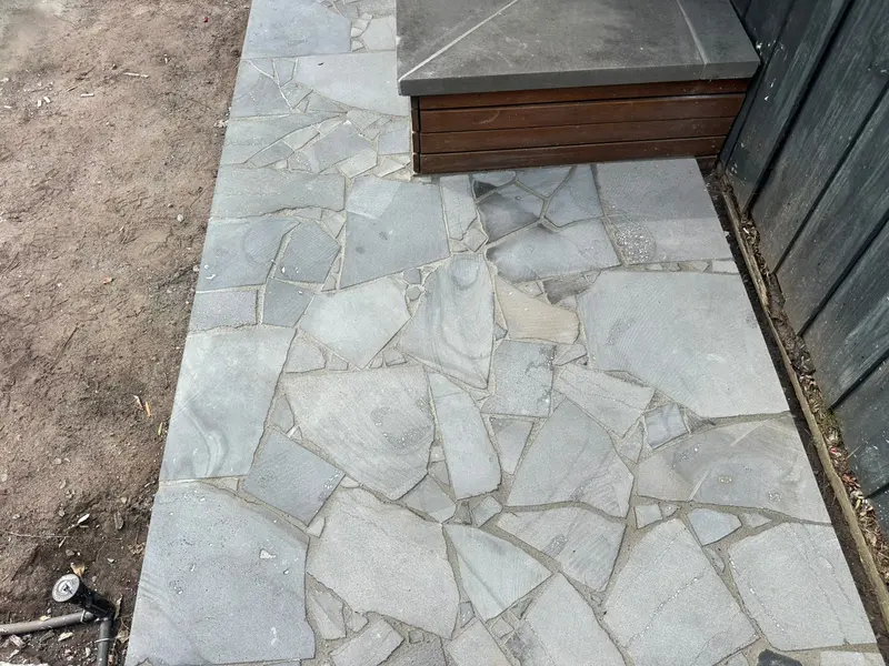 Bluestone capping on a timber planter above bluestone crazy paving