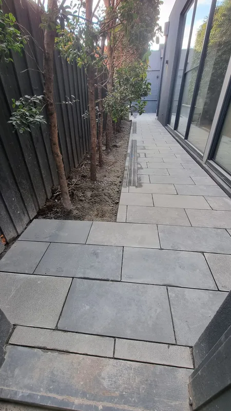 Bluestone paver side path along a timber fence