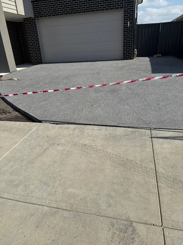 Charcoal concrete driveway to a double garage