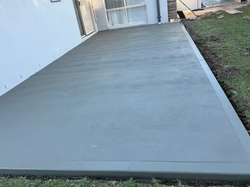 Finished concrete patio slab behind a new home