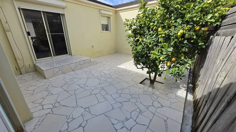 After: limestone crazy paving courtyard with steps and a lemon tree