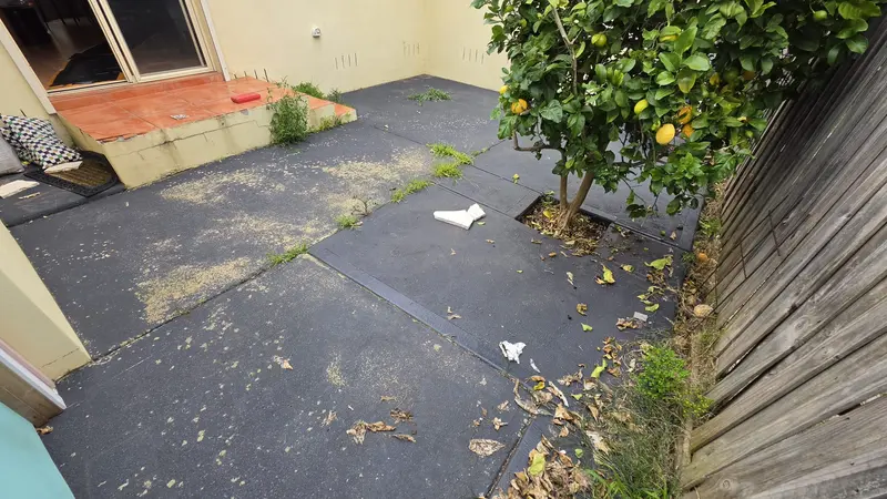 Old cracked asphalt courtyard before being replaced with limestone crazy paving