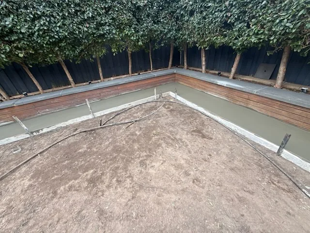 Concrete edge strip poured inside timber formwork around a new paved area