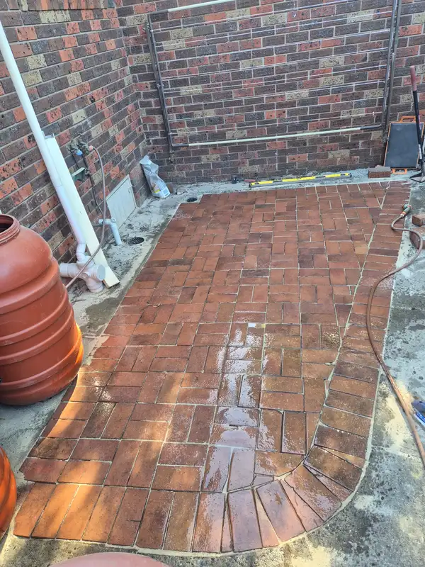 Recycled brick paving with a curved soldier-course edge