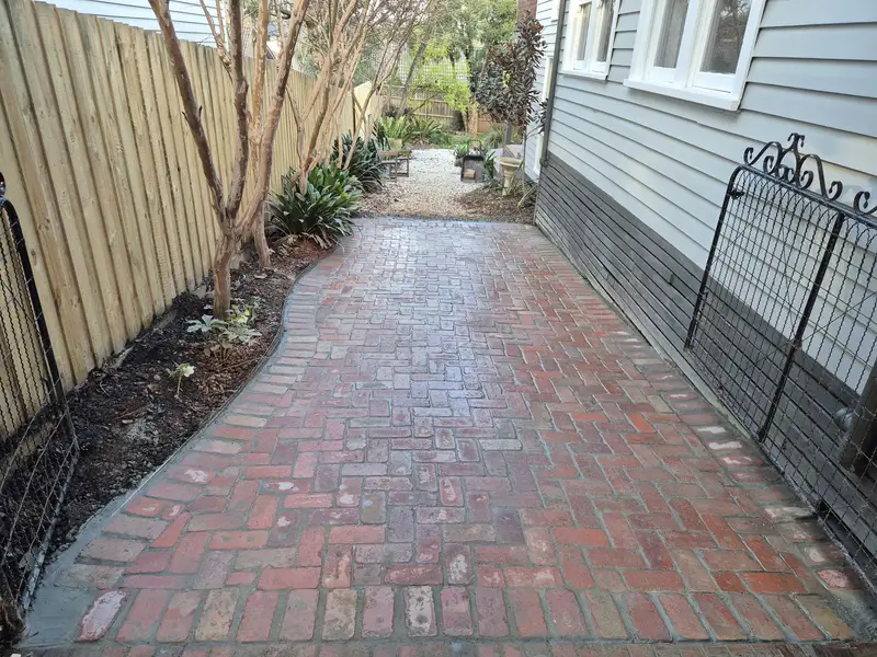 Recycled brick pathway beside a weatherboard home