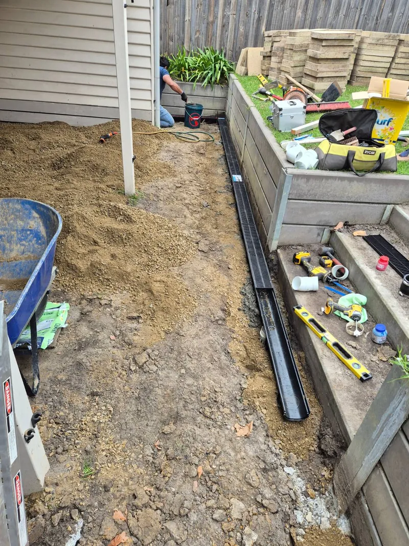 Installing a grated strip drain along a retaining wall — Antonio PrimeScape Construction, Melbourne