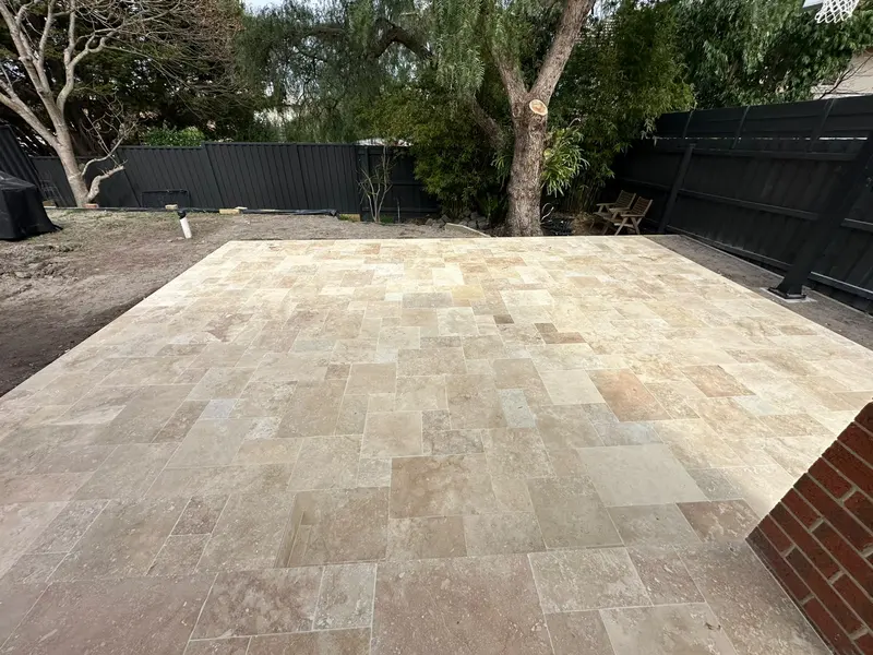 Travertine patio stretching across a Melbourne backyard